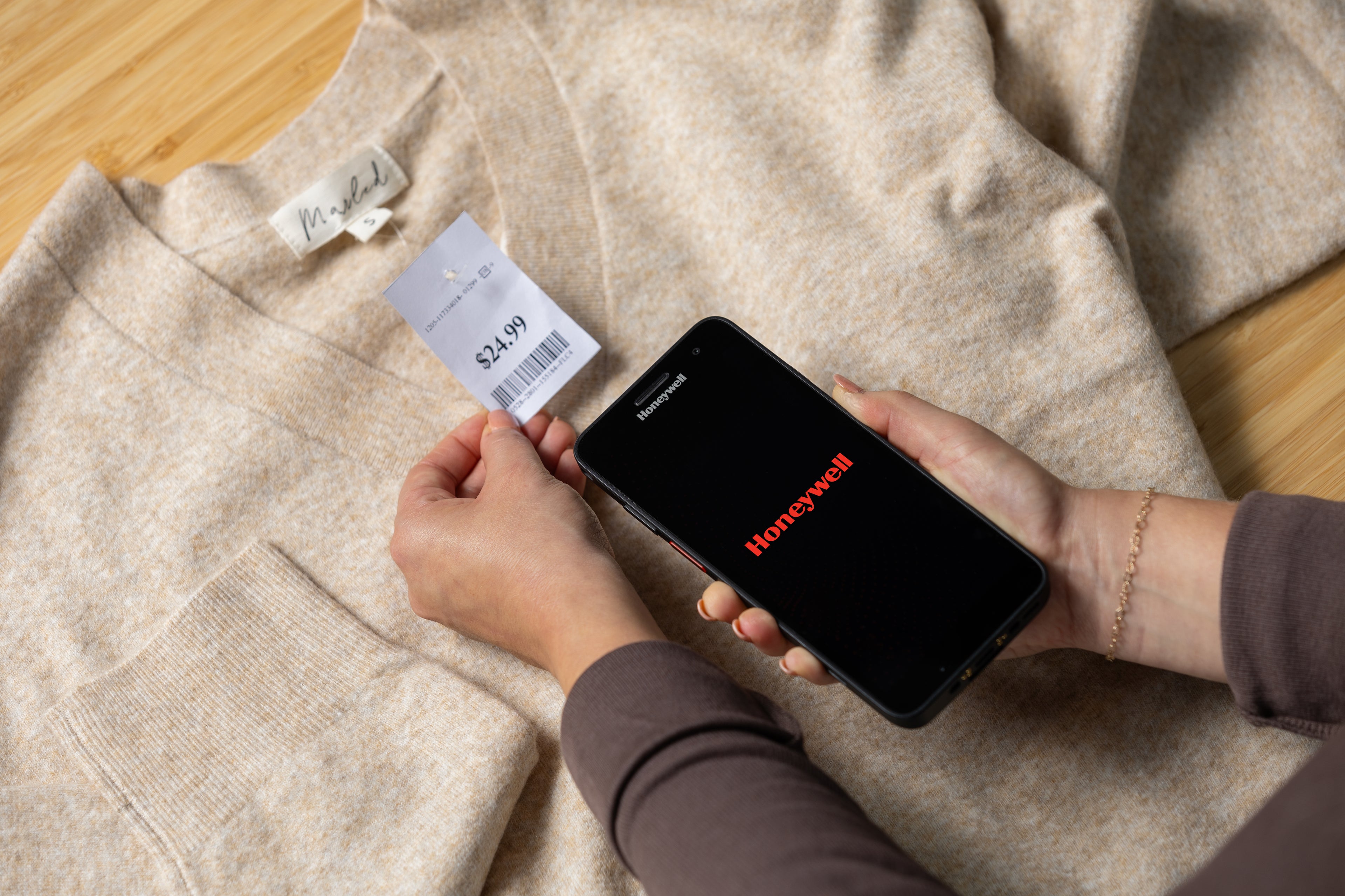Person using a smartphone to scan a product barcode on a piece of clothing.