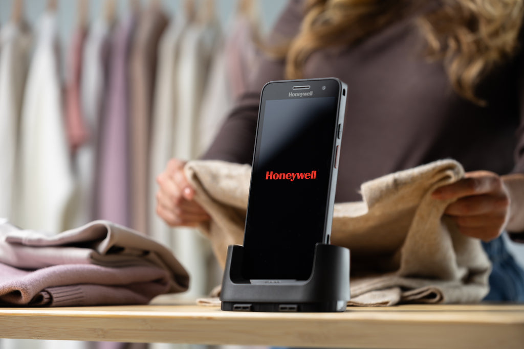 Smartphone on a stand with Honeywell logo in a clothing store setting